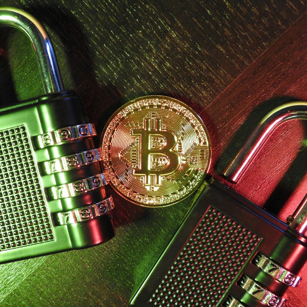 Bitcoin coin with combination padlocks on a wooden surface, symbolizing cryptocurrency security and encryption.