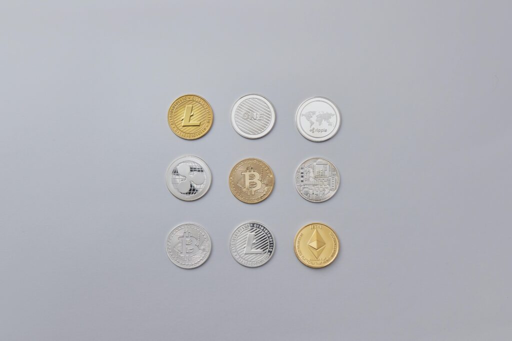 Image showcasing a selection of different cryptocurrency coins arranged on a neutral grey background.