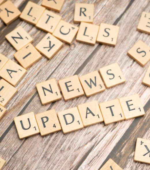 Scrabble tiles spelling 'News Update' on a wooden background, ideal for media and communication concepts.