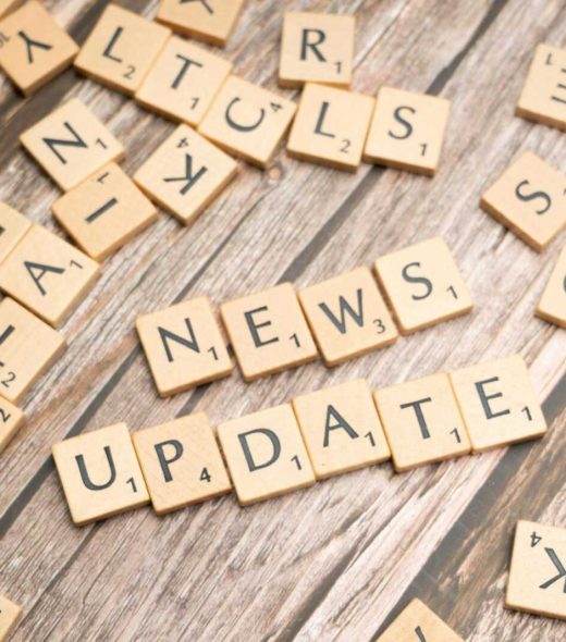 Scrabble tiles spelling 'News Update' on a wooden background, ideal for media and communication concepts.