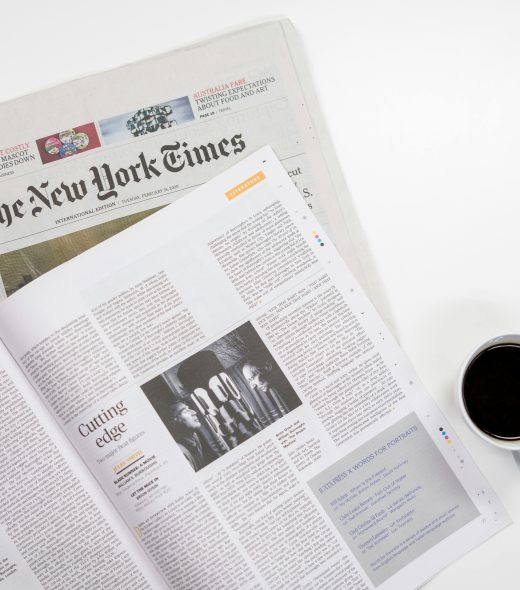 Flat lay of a coffee cup and The New York Times newspaper, ideal for business and lifestyle themes.