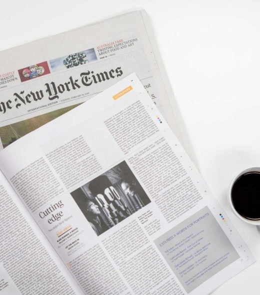 Flat lay of a coffee cup and The New York Times newspaper, ideal for business and lifestyle themes.