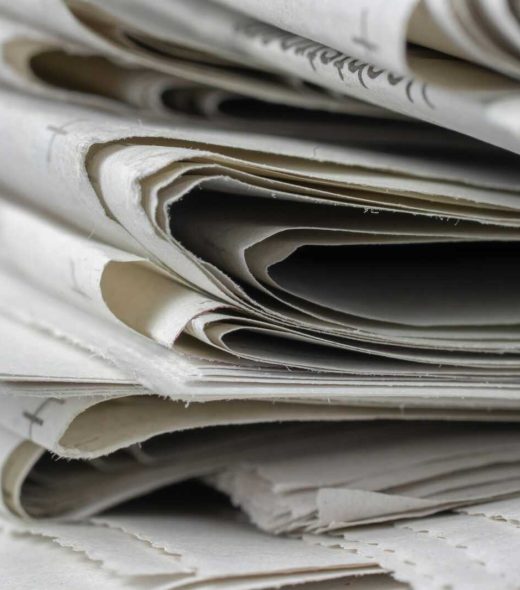 A detailed close-up view of stacked newspapers, highlighting textures and layers.
